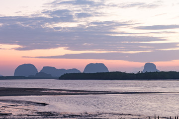 Landscape of riverside with mountains behind during the sunrise.