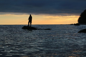 fisherman standing on a rock