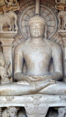 Fototapeta na wymiar Escultura de un dios indio sentado en el templo Parshvanatha . Khajuraho. Madhya Pradesh . India 