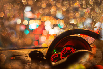 Inside car with bokeh lights from traffic jam on night time for background.