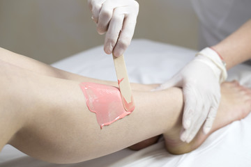 Process depilation female legs and hands in a beauty salon