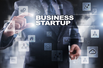 Businessman selecting business startup on virtual screen.