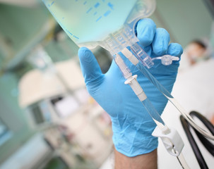 Intravenous drip with doctor hand in ward