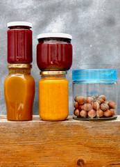 Jars with jam and nuts on the shelf