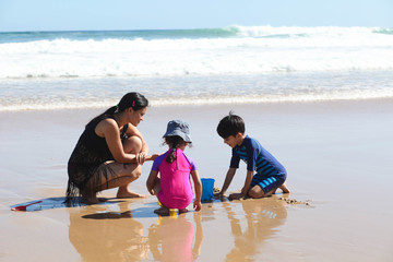 mother and kids playing on the beach