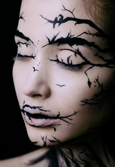 beautiful woman with creative make-up halloween tree make-up