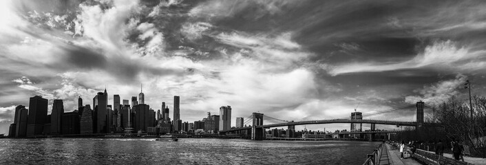 Manhattan and Brookyln bridge over the river in panorama black and white style