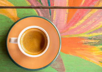 Top view of hot coffee on a colorful painted table