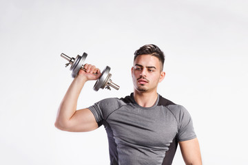 Fototapeta na wymiar Fitness man holding dumbbell, working out, studio shot.