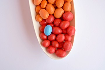 Chocolate lentils in an elongated shape in front of different background colors