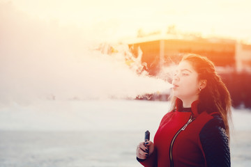 vaping girl holding a mod device. cloud of vapor. Vape