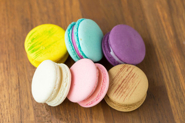Tasty macaroons with almond on wooden background