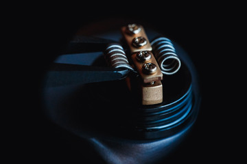 male master installs a coil. Spiral for electronic evaporator and cigarette. Vape, vaping. Firing a...