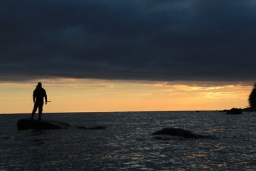 Fototapeta premium fisher man standing on a rock 