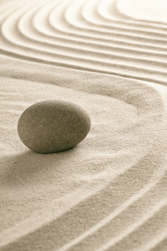 stone on raked sand in Japanese zen garden.