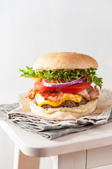 bacon cheese burger with beef patty, tomato and onion