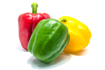 Red green and yellow bell peper on white background.