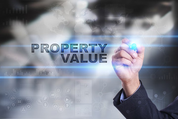 Fototapeta na wymiar Businessman is drawing on virtual screen. property value concept.