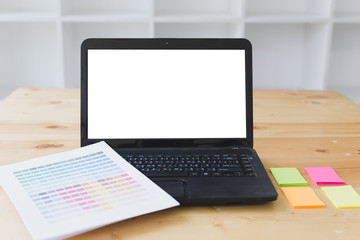 graphic designer desk table with computer, sticky note and color guide palette swatches