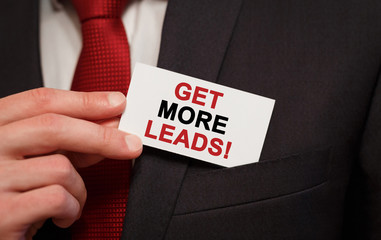 Businessman putting a card with text Get More Leads in the pocket