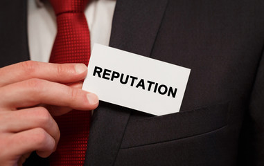 Businessman putting a card with text Reputation in the pocket