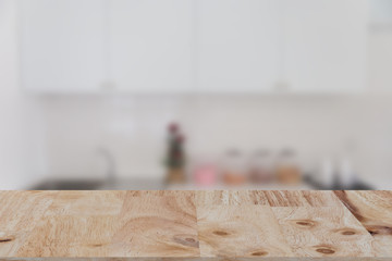 blurred white kitchen bench interior with selected focus wood table for montage or display your product