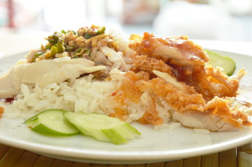crispy deep fried and boiled chicken on cooked rice dressing different sauce on plate
