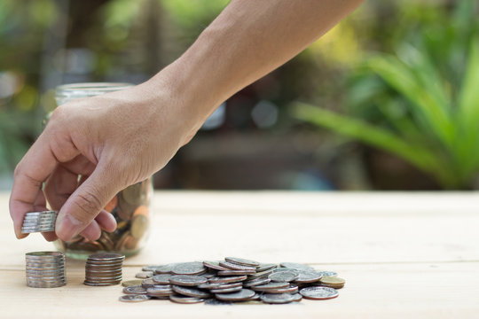 Hand hold coin on wooden table