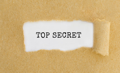 Text Top Secret appearing behind ripped brown paper.