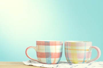 Coffee cup put on wooden in blue wall room. Pastel tone with copy space.