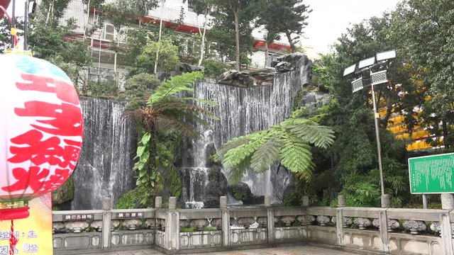 Waterfall and foliage inside Longshan Temple in Taipei, Taiwan. The waterfall is there to help cleanse your mind and spirit before entering the temple. 4K