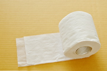 white tissue paper rolling on brown hard sheet board