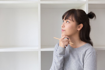 asian girl female teenager student thinking something beside bookshelf