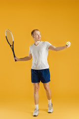 young tennis player plays tennis on yellow background
