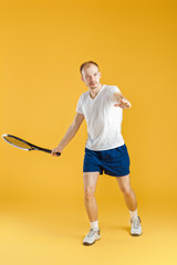 young tennis player plays tennis on yellow background