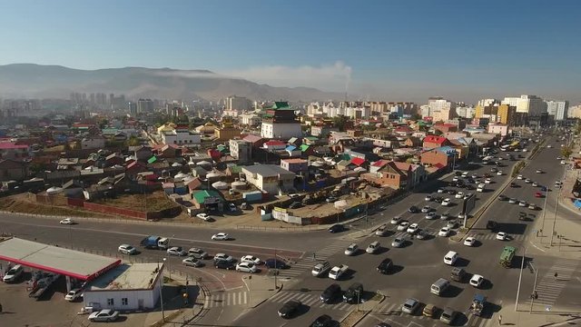 Cinematic aerial flight above road to Gandan Gandantegchinlen Chinese-style Tibetan Buddhist Monastery. Center of Mongolian capital of Ulaanbaatar. Religion world famous attraction. Sunny day