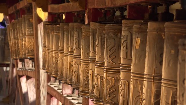 Gold prayer wheels spinning details Gandan Gandantegchinlen Chinese-style Tibetan Buddhist Monastery. Center of Mongolian capital of Ulaanbaatar. Religion world famous attraction. Colorful sunny day
