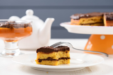 Tea table with teaware, low callorie pumpkin dessert and homemade layered pumpkin cake with chocolate ganache
