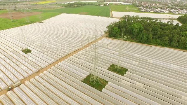 Aerial agricultural landscape with a power pole between greenhouses