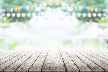 Empty wooden table with party in garden background blurred.