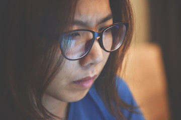 Fototapeta premium Stressed Asian eyeglasses woman working overtime. Copy space.