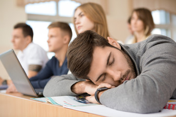 Male university student sleeping in class