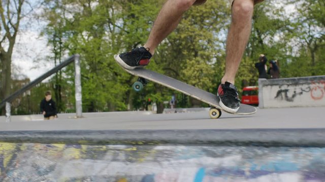Skateboarder doing a nose manual trick falls over, in slow motion 