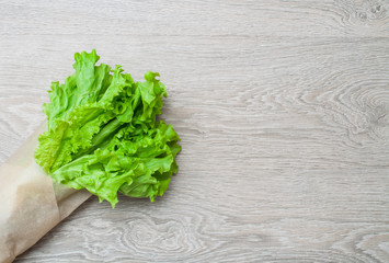 Leaves of green salad on a wooden background. View from above