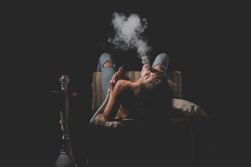 Woman in jeans smoking hookah