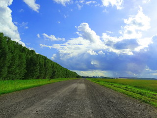 Fototapeta na wymiar Blue sky with white clouds. The road into the distance.