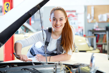 Fototapeta Young female mechanic working on car engine obraz