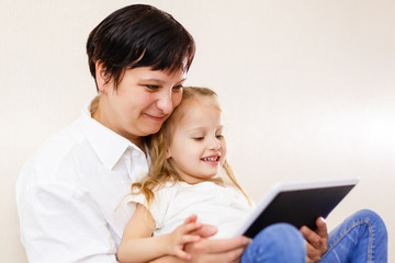 Fototapeta na wymiar Mom and daughter using tablet Mother and daughter using tablet computer together