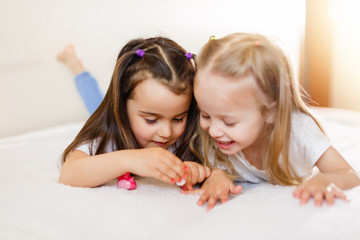 Two little girls painted their nails at home