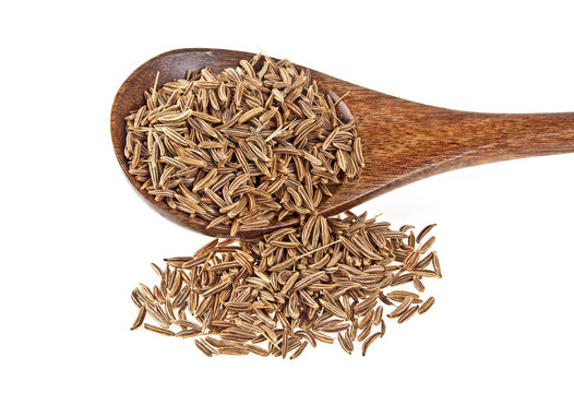 Cumin seeds in wooden spoon on a white background